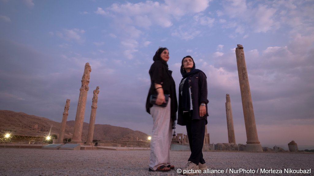Two young Iranian women pose for a photograph while visiting the Persepolis historical site near Shiraz, Iran, on October 9, 2024 | Photo: Morteza Nikoubazl/NurPhoto / picture alliance