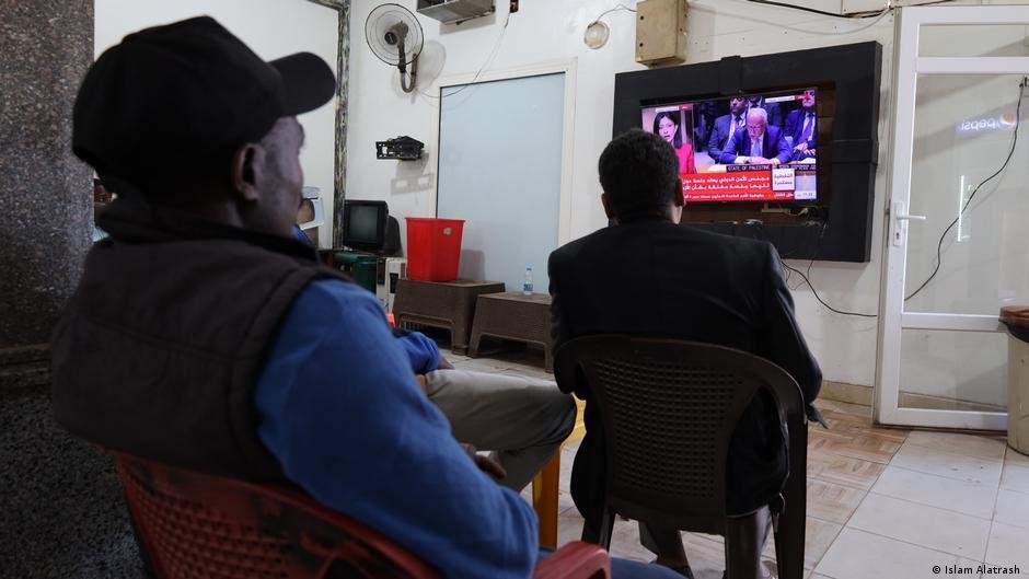 Isaac, Fadel et d'autres Soudanais vivant à Misrata, en Libye, se retrouvent après le travail dans ce café pour regarder ensemble les informations sur le Soudan. Crédit : Islam Alatrash