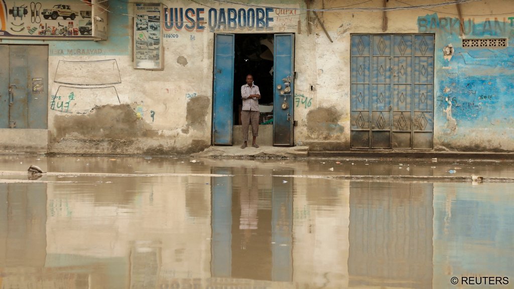 Muse Ahmed stands in front of his flooded spare parts shop after heavy rain in Mogadishu, Somalia, October 12, 2026 | Photo: Feisal Omar / Reuters