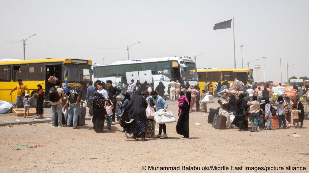 File photo: Afghan deportees gather near buses at the Islam Qala border crossing in Afghanistan, on July 4, 2025 | Photo: Muhammad Balabuluki / Middle East Images / picture alliance