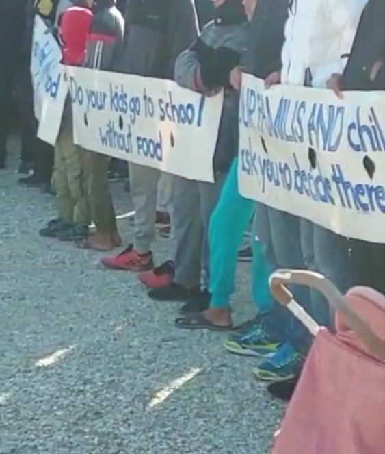 Des banderoles déployées pendant la manifestation. On peut y lire : "Do your kids go to school without food?" Crédit : capture d'écran d'une vidéo envoyée à InfoMigrants