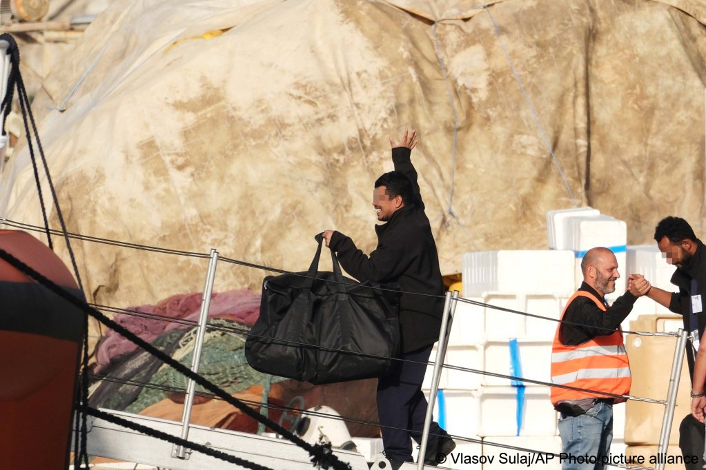 A migrant intercepted in international waters and sent to a reception facility in Albania earlier this week, boards an Italian coast guard vessel at the port of Shengjin, Albania, with destination Italy after a court in Rome rejected their detention | Photo: Vlasov Sulaj/AP Photo/picture alliance