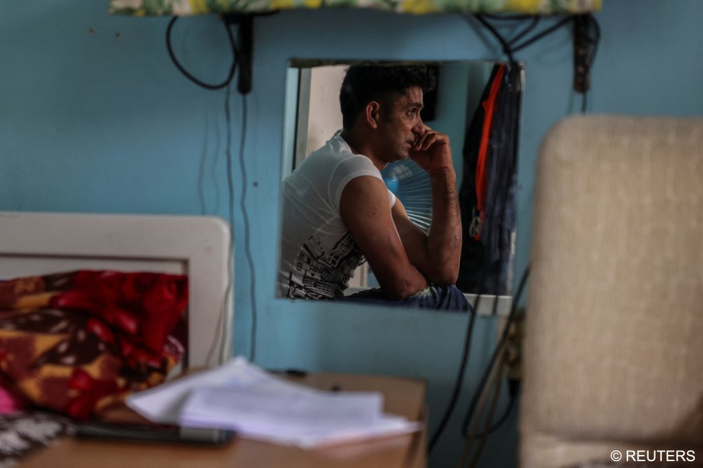 Adil Hussain cries in his small room in Athens, he vows to leave the door to his home open until he knows what became of his brother | Photo: Stelios Misanas / Reuters