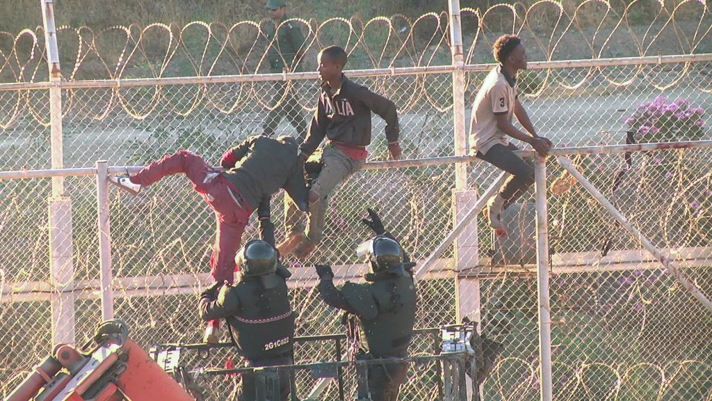 File photo: Migrants attempting to climb the barbed wire fence between Morocco and the Spanish enclave of Ceuta | Photo: Reuters