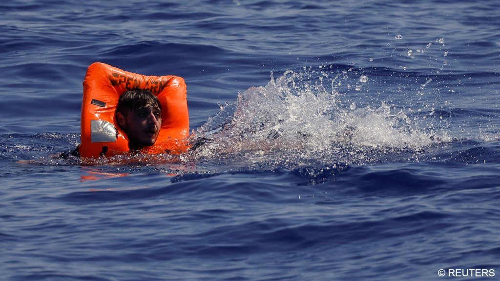 File photo: Members of the NGO rescue vessel Astral, run by Open Arms, throw life vests to migrants on a wooden boat off Lampedusa in August 2024 | Photo: Reuters