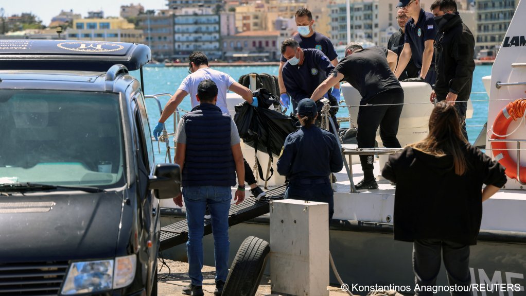 Greek coast guard officers carry the covered body of a migrant to be transferred to Chios General Hospital for an autopsy| Photo: Konstantinos Anagnostou / Reuters