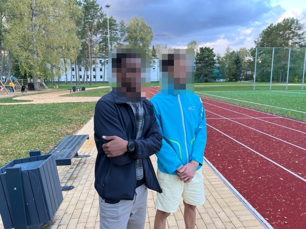 Musab (left) and Abbas standing next to a soccer field in the village of Mucenieki in Latvia on September 29, 2024 | Photo: Benjamin Bathke/InfoMigrants