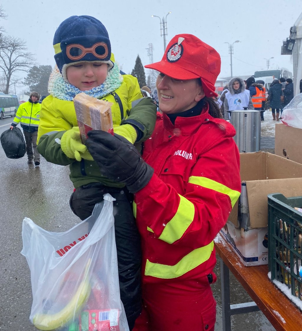 Un enfant et une humanitaire au poste-frontière de Siret. Crédit : InfoMigrants