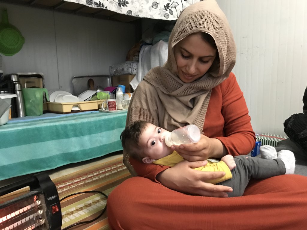 Manal, from Syria, offers a bottle of cow's milk to her 6-month-old baby. She managed to buy some at the supermarket because it is not provided with the food packages for infants and her baby is refusing formula | Photo: Ignacio Pereyra 