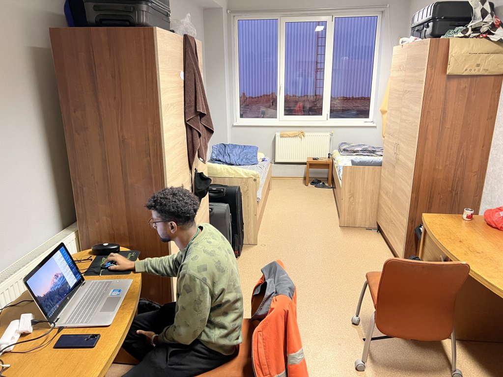 Saleh Othman sitting at the desk of his dormitory room on September 30, 2024 | Photo: Benjamin Bathke/InfoMigrants