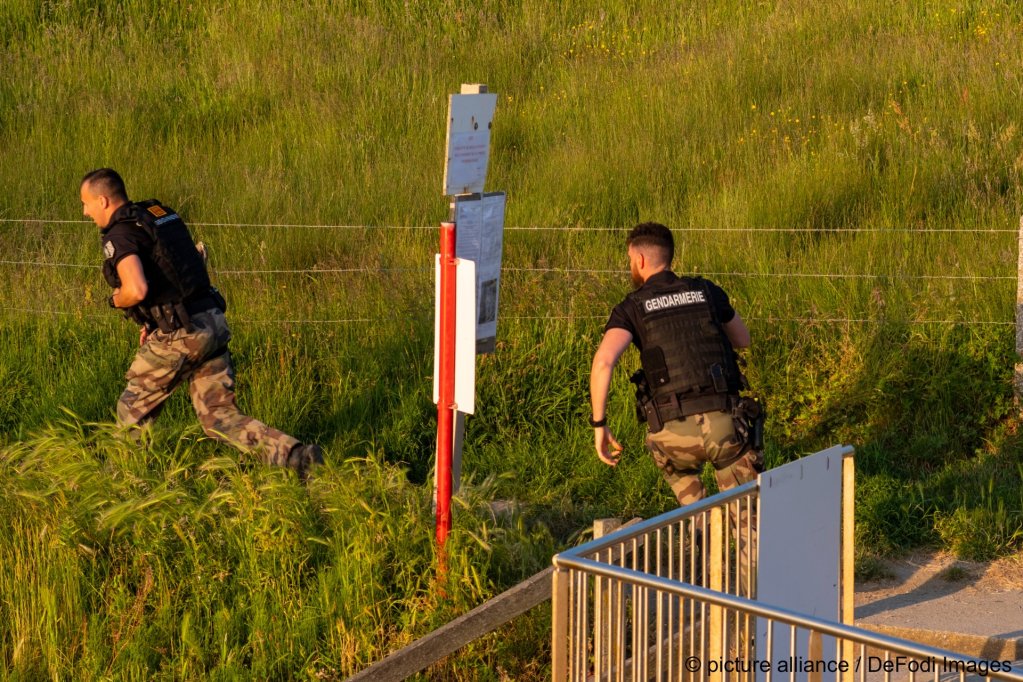 French policemen run towards a beach where migrants are attempting to launch a boat towards the UK | Photo: Volke / DeFodi Images / picture alliance