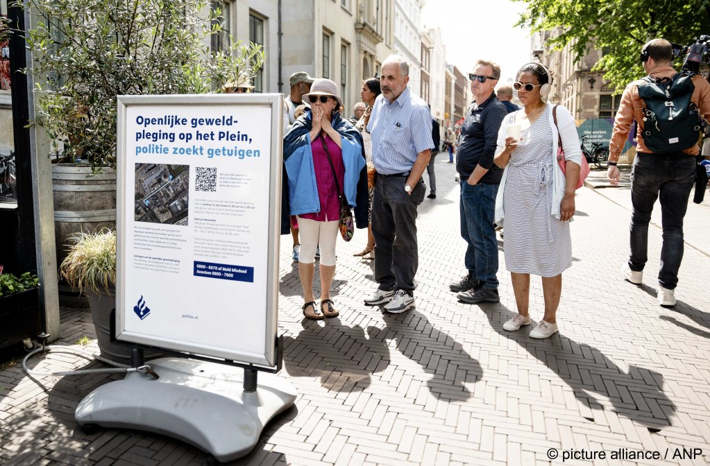 Passersby in the Hague look at police information boards and react in shock as they read about a fatal attack on a Somali asylum seeker in July 2024 | Photo: Lina Selg /picture alliance / ANP