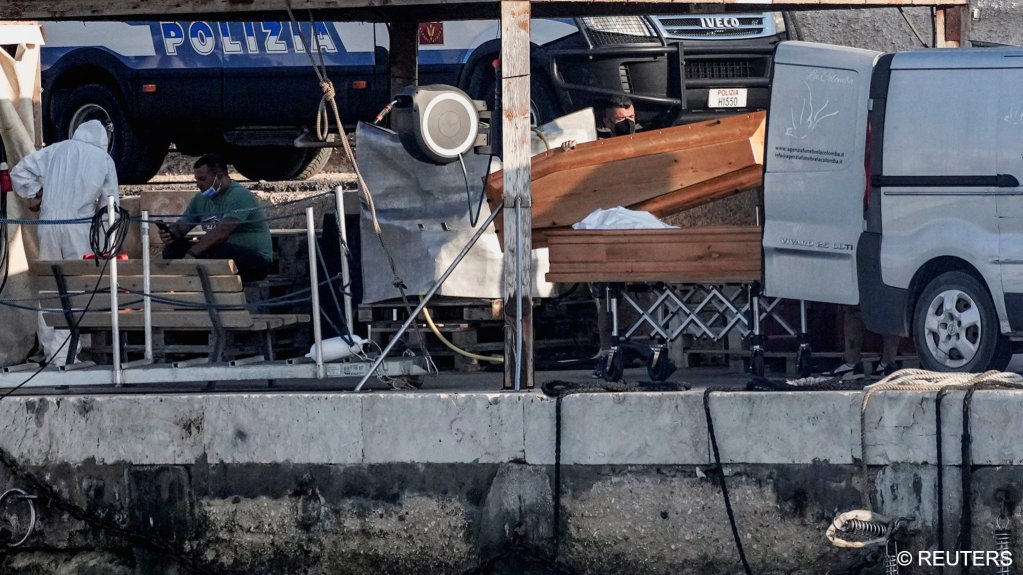 A body lies in a coffin on the dock after a migrant shipwreck on the southern Italian island of Lampedusa on August 13, 2025 | Photo: Chiara Negrello / Reuters