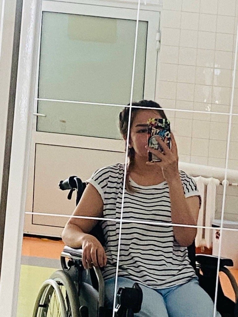 Hila sits in a wheelchair after her operations | Photo: Private