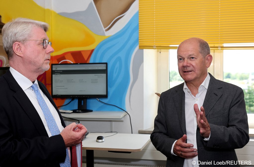German Chancellor Olaf Scholz talks to BAMF President Eckhard Sommer during his visit to the Federal Office for Migration and Refugees (BAMF) in Nuremberg, July 8, 2024 | Photo: Daniel Loeb / Pool via REUTERS