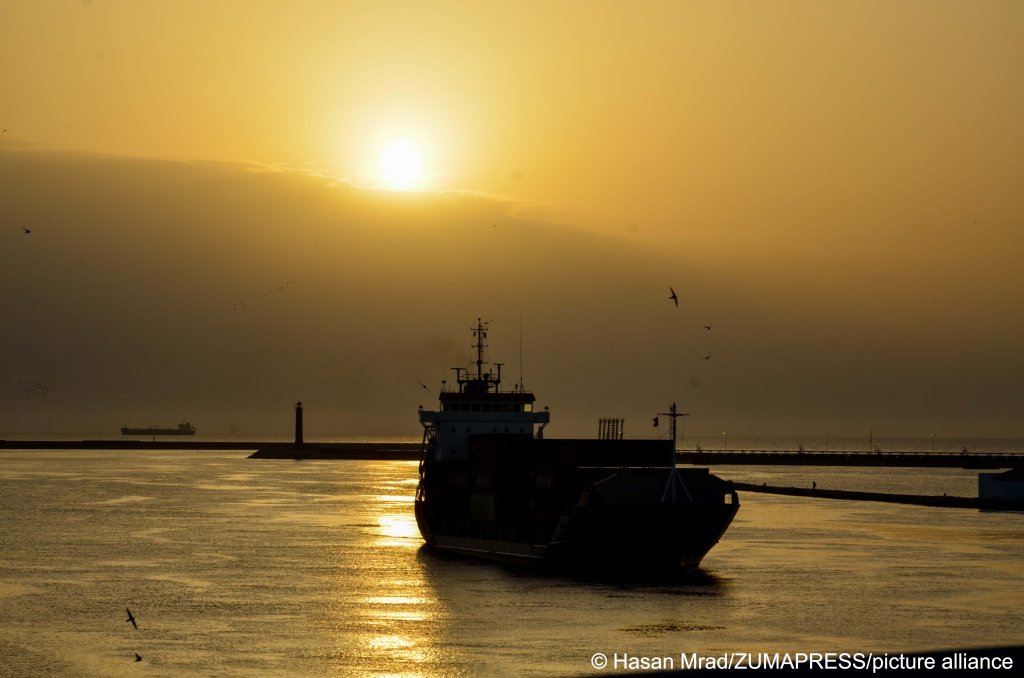 From file: A cargo ship loaded with containers is seen crossing the port of Bizerte in Tunisia at sunset | Photo: Hasan Mrad / picture alliance / Zuma press