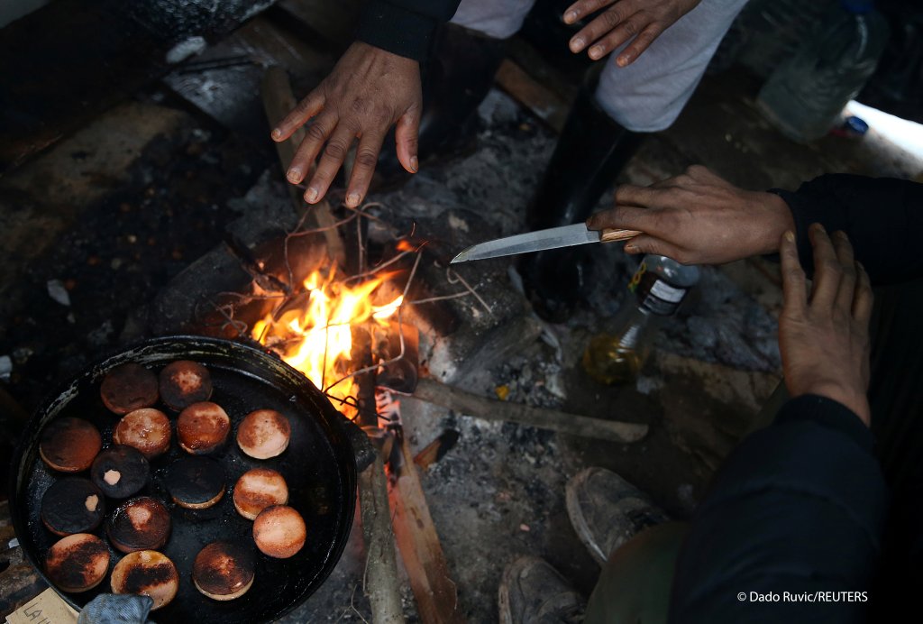 المهاجرون يطبخون على نار داخل المخيم في البوسنة والهرسك، 30 يناير 2021 
