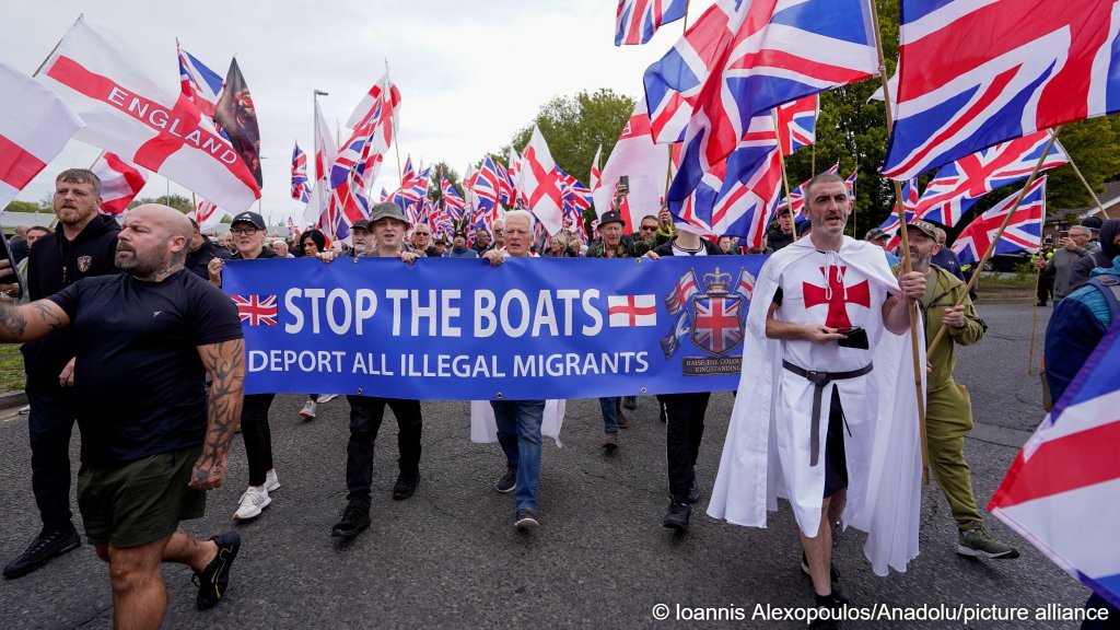 Supporters of the far-right Britain First party wave Union Flags and St George' s flags during an anti-immigration rally in Tamworth, United Kingdom, on September 12, 2026 | Photo: Joannis Alexopoulos/Anadolu