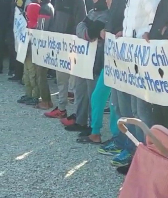 در ویدیوهایی که به دست مهاجر نیوز رسیده زنان مهاجر  پارچه‌هایی را در دست دارند که در آن نوشته شده: «کودکان شما بدون غذا به مکتب می‌روند‌؟». عکس از ویدیوی ارسالی به مهاجر نیوز