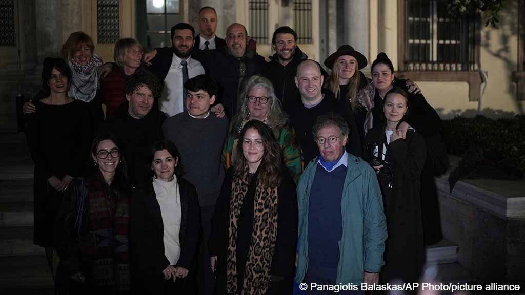 Rescue volunteers and their lawyer pose outside a courthouse in Mytilene, on the northeastern Aegean island of Lesbos, Greece, Thursday, Jan. 15, 2026, after being acquitted of charges related to aiding migrants. (AP Photo/Panagiotis Balaskas)
