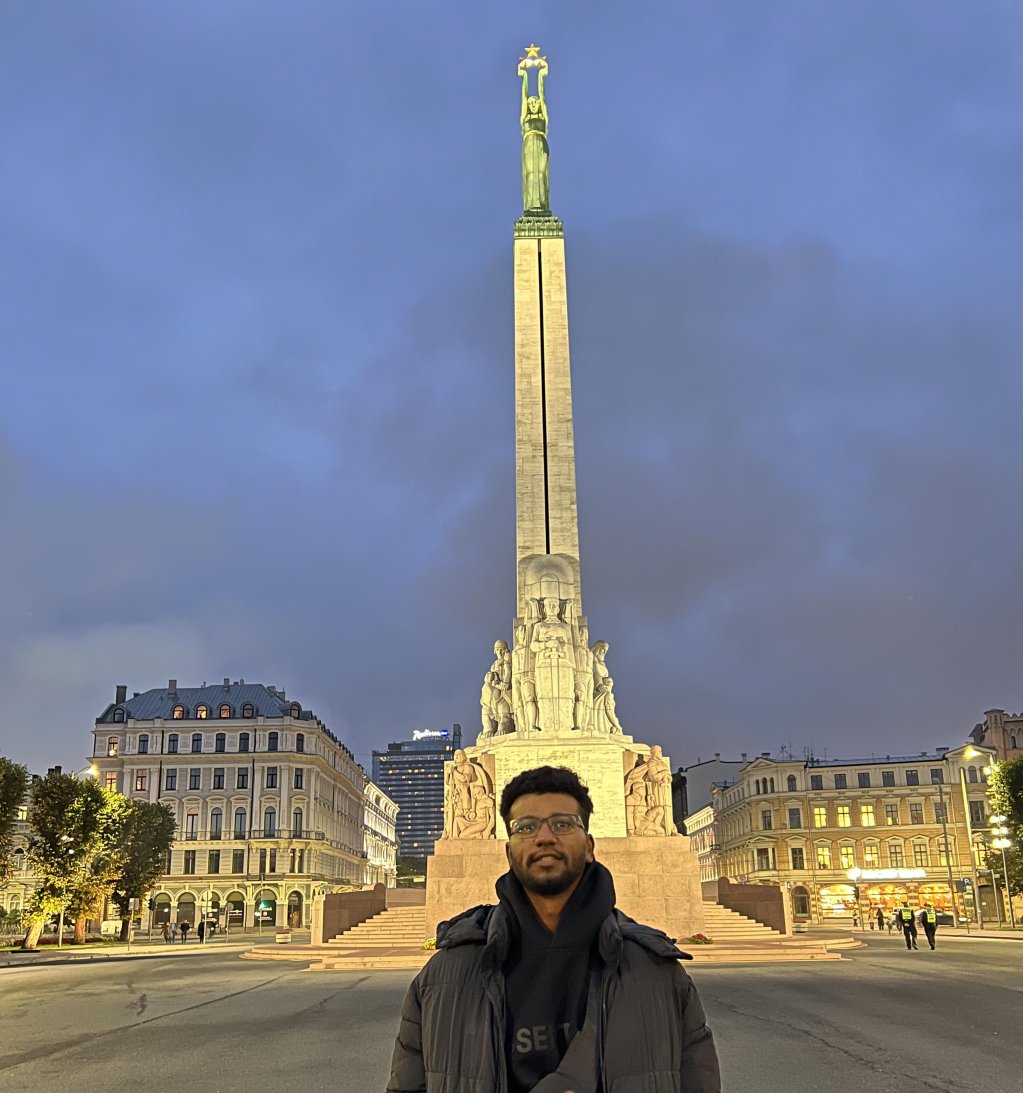 Saleh standing in front of Riga's Freedom Monument | Photo: Benjamin Bathke/InfoMigrants