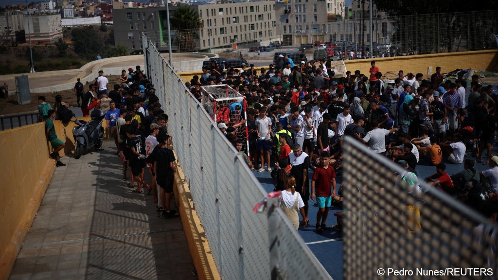 Migrants from Morocco gather at a sports feld to be registered, following recent mass crossings of migrants from Morocco into Ceuta | Photo: Pedro Nunes/Reuters