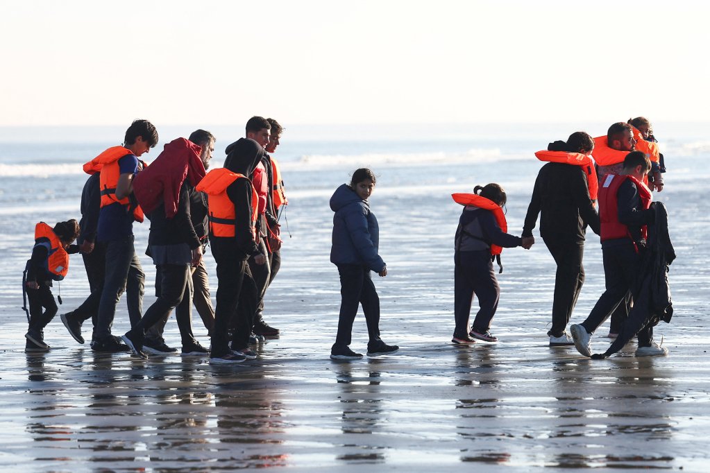 File photo: Migrants walk away from the beach after a failed attempt to cross the English Channel to reach Britain | Photo: Abdul Saboor / Reuters