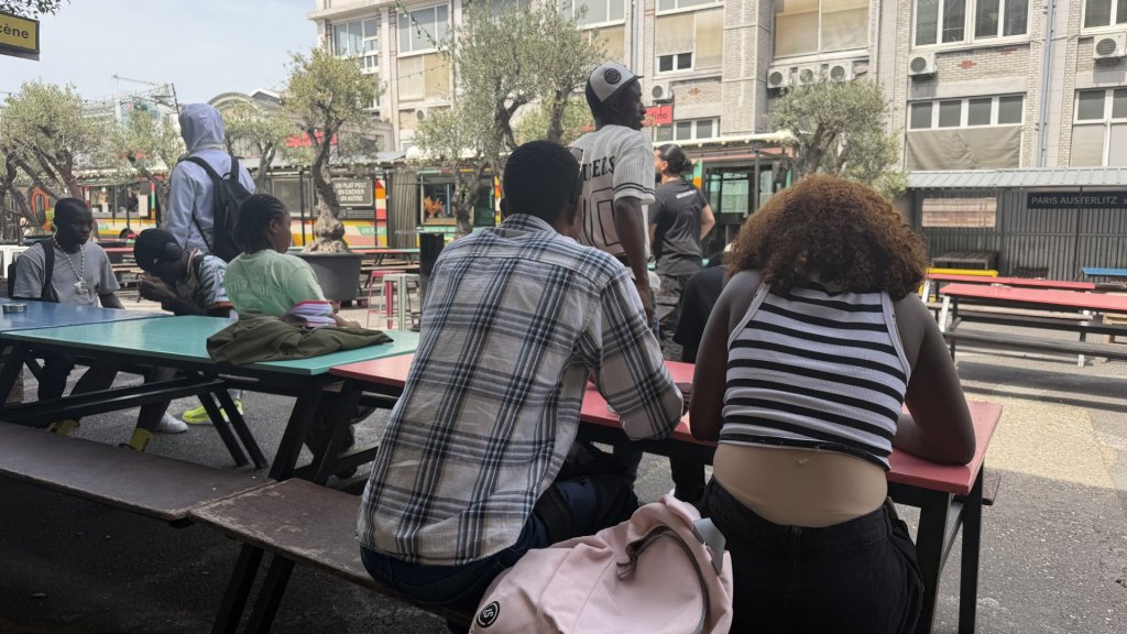 Trésor (center), a 17-year-old from the Democratic Republic of Congo, and Makoura (right), a 17-year-old from Guinea, at Ground Control in Paris, May 2026 | Photo: InfoMigrants