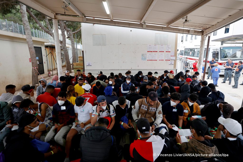 From file: Migrants are seen waiting inside the 'hotspot' reception center on Lampedusa, which is run by the Red Cross | Photo: Vincenzo Livieri / ANSA / picture alliance