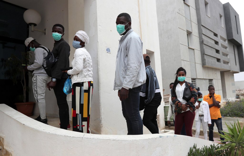 African immigrants queue for aid boxes distributed by the Raoued town hall in Tunis, Tunisia | Photo: EPA/MOHAMED MESSARA