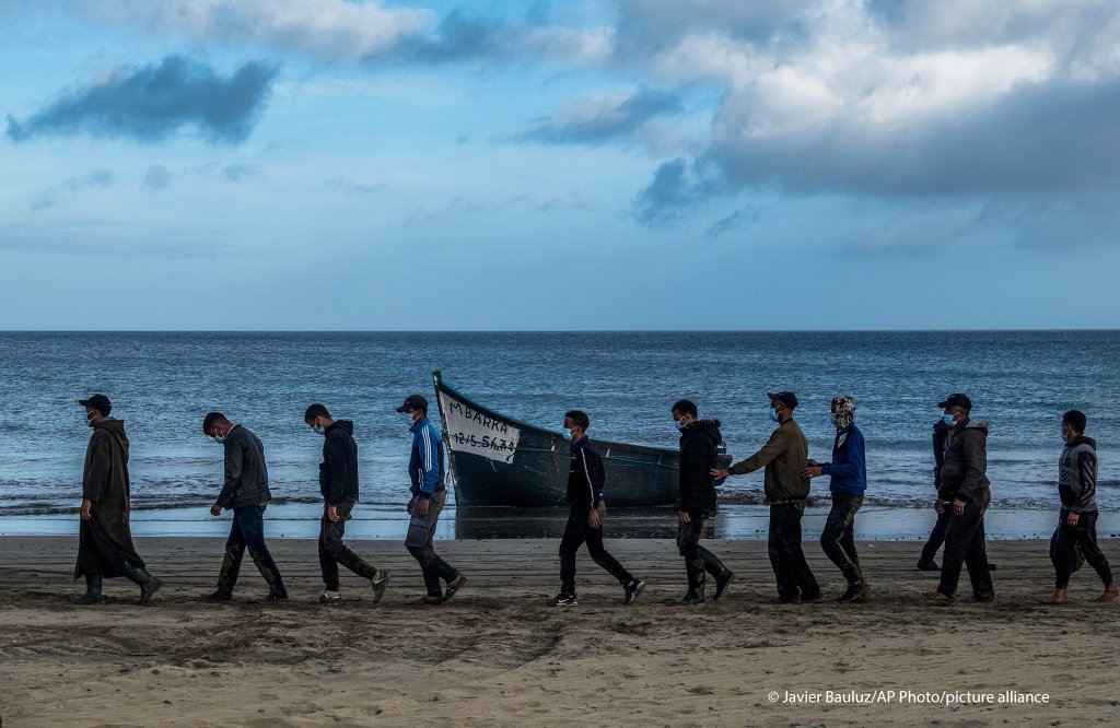 Migrants from Morocco walk along the shore escorted by Spanish Police after arriving at the coast of the Canary Island | Photo: Javier Bauluz /AP Photo