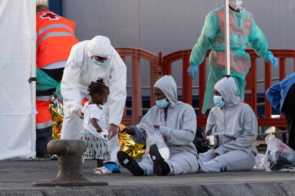A member of the Spanish Red Cross helps a child upon arrival at Los Cristianos Port, in Tenerife, Canary islands, Spain, 26 June 2021 | Photo: EPA/Ramon de la Rocha
