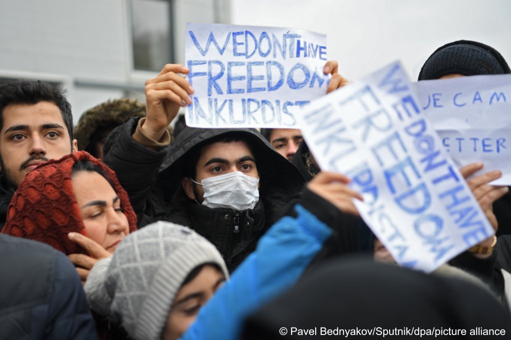 Protestors hold signs reading "We don't have freedom in Kurdistan" at the Bruzgi logistics center where migrants and refugees are being housed near the Belarusian-Polish border | Photo: Pavel Bednyakov/Sputnik/dpa/picture-alliance
