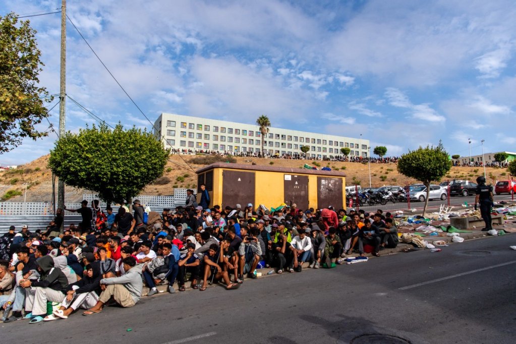 Des migrants patientent sur le trottoir avant d'être enregistrés par les autorités dans le quartier de Loma Colmenar à Ceuta, le 31 août 2026. Crédit : Reuters
