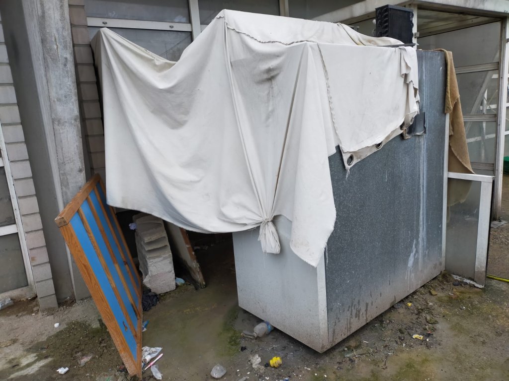 The migrants have built an outside cabin, where they shower using a bucket | Photo: InfoMigrants