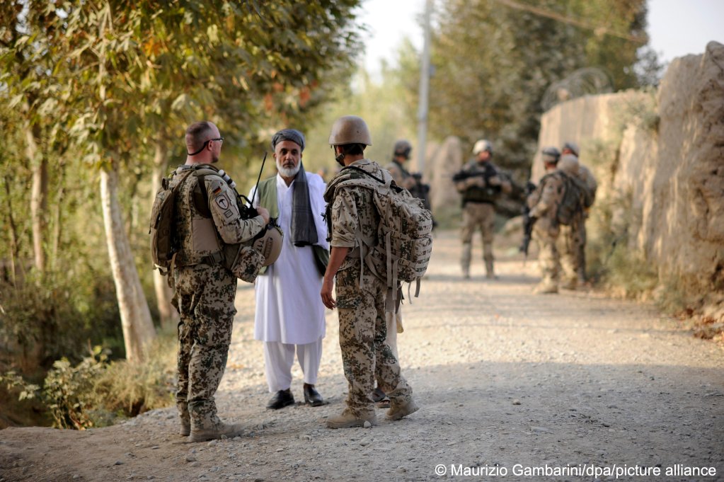 Working side-by-side for years: An Afghan interpreter (r.) and a Bundeswehr soldier (l.) speak to a local near Kundus | Photo: Picture alliance/dpa/Maurizio Gambarini