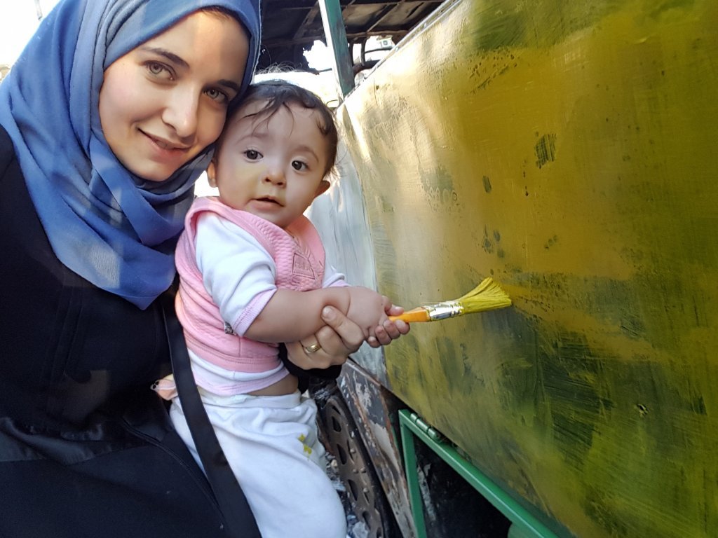 Waad Al Kateab and Sama paint a bus destroyed in the Syrian war | Photo: With kind permission of the Action for Sama campaign