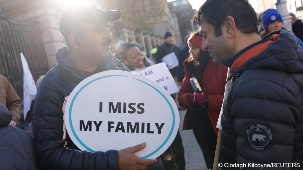 People hold placards at a rally calling for fair rights for migrant workers, in Dublin, Ireland, November 20, 2025 | Photo: Clodagh Kilcoyne / Reuters
