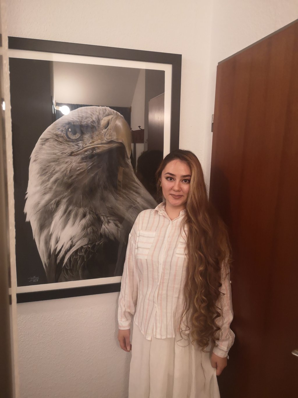 Kaya Jafari poses next to her charcoal and pastel drawing of an eagle | Photo: Natasha Mellersh