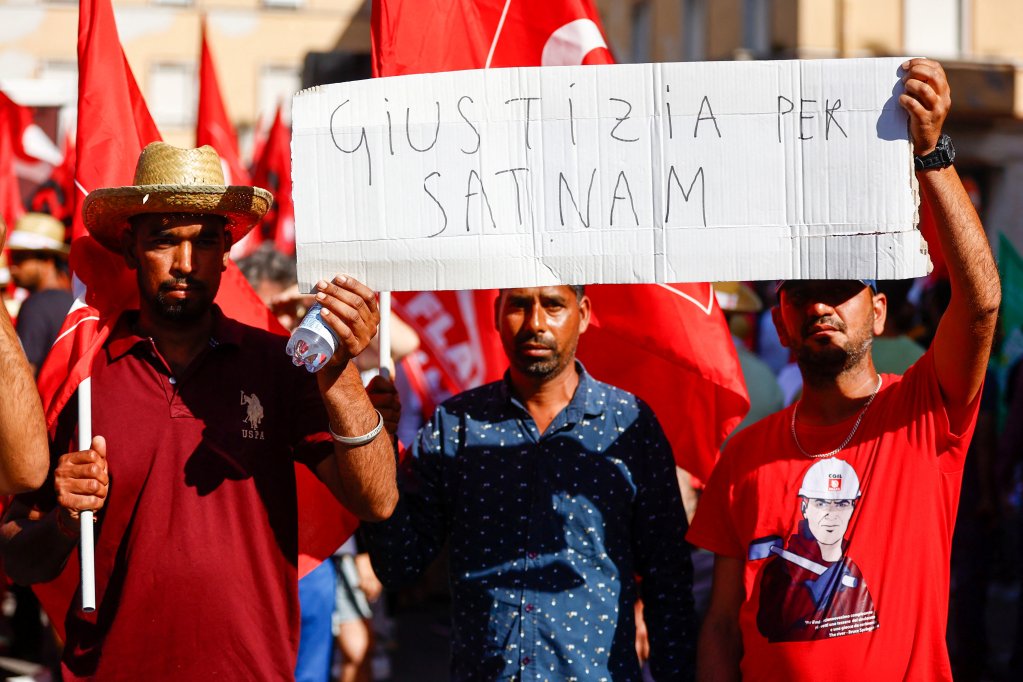 Two immigrants present at the protest holding placards written in Italian. Photo: Reuters