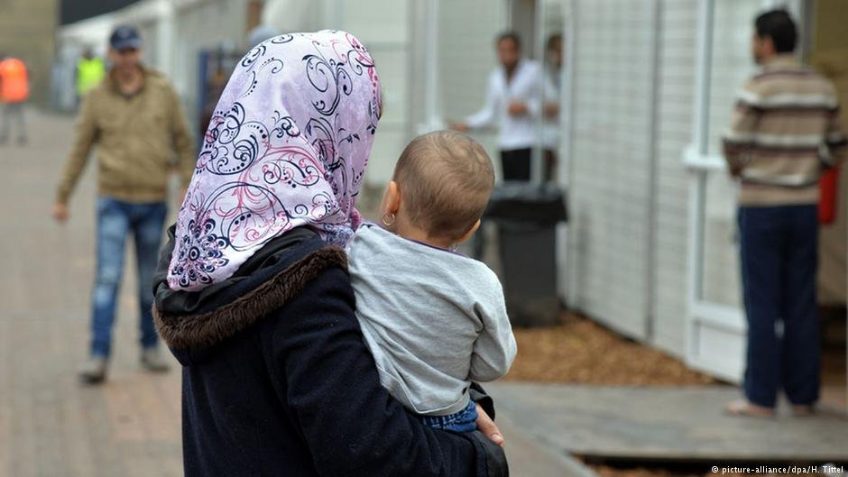 From file: A woman carries her child in an initial reception facility in Bitburg, Germany | Photo: H. Tittel/dpa/picture-alliance