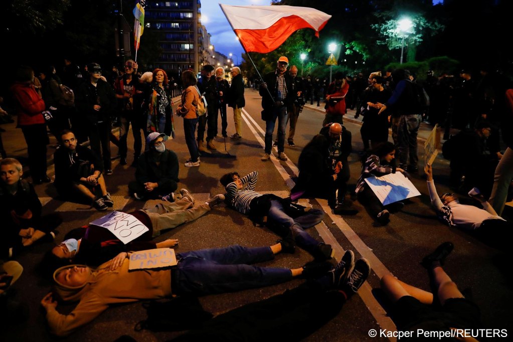 People lie on the ground in front of the Parliament in Warsaw, Poland on September 6, 2021 with signs reading "They will die" during a protest against the state of emergency declared at the Polish-Belarusian border | Photo: Kacper Pempel/Reuters