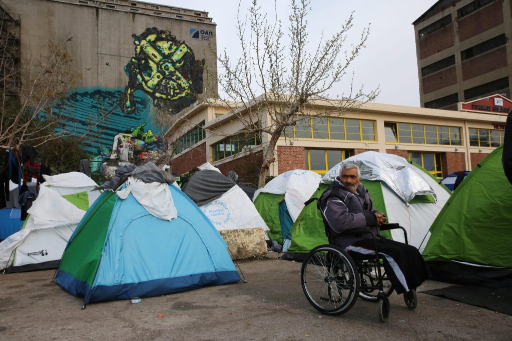 File photo: A disabled man from Syria sitting outside his tent at a temporary facility at the port of Piraeus near Athens, Greece | Photo. Oresis Panagiotou / EPA