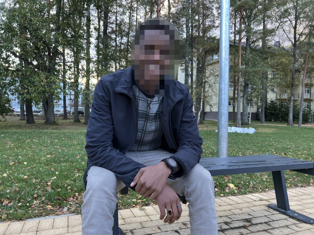 Musab (name changed) sitting next to a soccer field in the village of Mucenieki in Latvia on September 29, 2024 | Photo: Benjamin Bathke/InfoMigrants