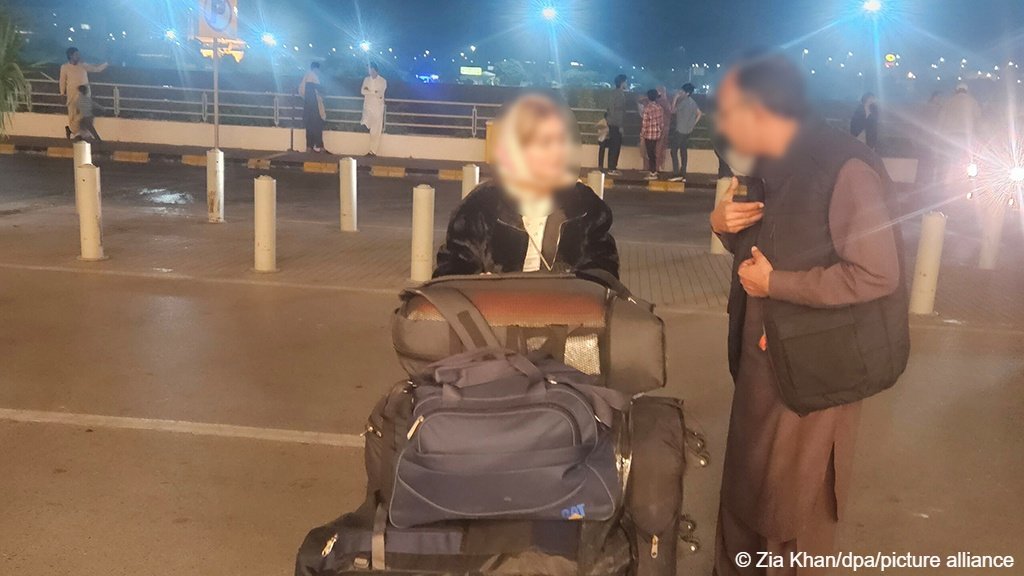 An Afghan woman, her trolley loaded with luggage heads towards a flight for Germany after waiting a long time in Pakistan for the permissions to come through to fly to Europe | Photo: Zia Khan / dpa / picture alliance