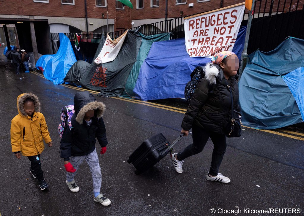 Some asylum seekers walk past the tents that were pitched outside the IPO before May 1, 2024, the Irish government has said makeshift encampments are not the solution | Photo: Clodagh Kilcoyne / Reuters