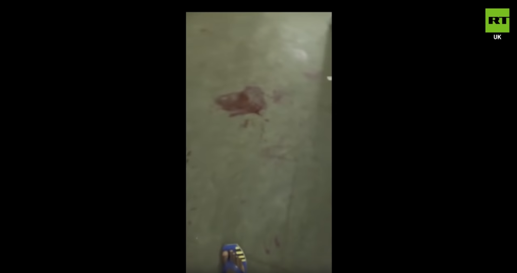 A mobile phone image of blood on the floor at the barracks in the RT TV report | Source: Screenshot RT