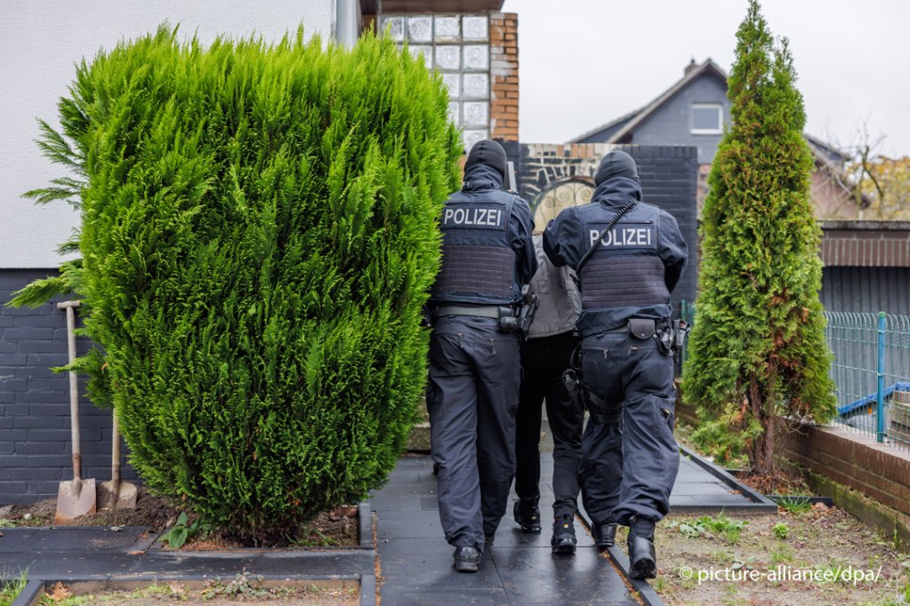 Policisté po zjištění totožnosti vracejí podezřelého do domu ve vilové čtvrti  Foto: Olli Spata/DPA/Image Alliance