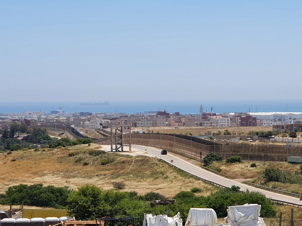 السياج الحدودي الفاصل بين مليلية والمغرب، ويبدو في الأفق ميناء بني أنصار المغربي، 18 أيار\مايو 2021. مهاجر نيوز