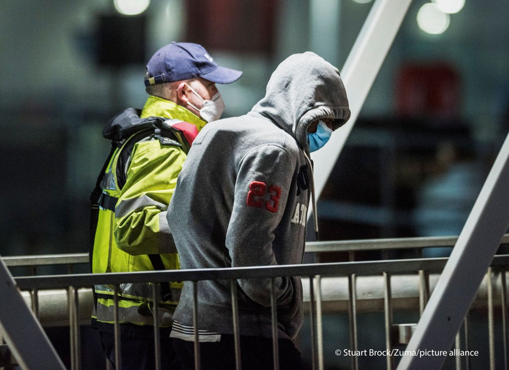A migrant is helped ashore by a Border Force officer at 3 a.m. at Dover Harbor in Kent after crossing the English Channel. Home Secretary Priti Patel has pledged an overhaul of asylum seeker rules, with refugees having their claim assessed based on how they arrive in the UK | Photo: picture-alliance/Stuart Brock